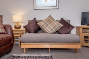 uma sala de estar com um sofá e almofadas em Achaniar Cottage em St Andrews