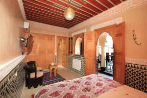 ein Schlafzimmer mit einem Bett und ein Zimmer mit einem Balkon in der Unterkunft Riad Moulay Spa in Marrakesch