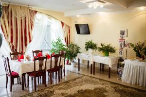 a dining room with tables and chairs and a tv at Vila Muntenia Hotel in Chişinău