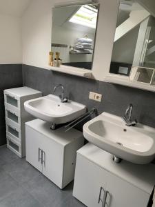 La salle de bains est pourvue de 2 lavabos et d'un miroir. dans l'établissement Erve Feenstra, à Lochem