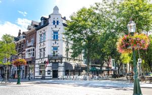 a street with a white building with a clock tower at Alex Maastricht in Maastricht