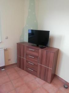 a wooden entertainment center with a flat screen tv on it at Ferienwohnung Hermann in Sankt Aldegund