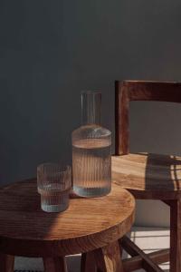 a wooden table with two glasses on top of it at OKU Ibiza in San Antonio