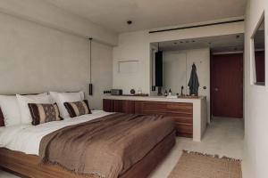 a bedroom with a large bed and a kitchen at OKU Ibiza in San Antonio