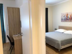 a bedroom with a bed and a desk with a chair at Tempus Apartment in Split