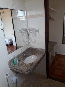 a bathroom with a sink and a mirror at Hotel Litoral in Aracaju