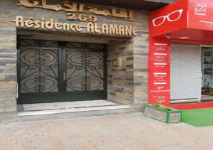 un devant de magasin avec une grande porte sur un bâtiment dans l'établissement Résidence Al Amane, à Casablanca