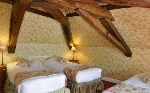 two beds in a room with wooden beams at Hôtel & Spa du Domaine des Thômeaux, The Originals Relais (Relais du Silence) in Mosnes