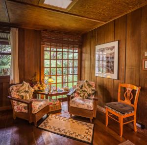 a living room with wooden walls and a table and chairs at Crater Rim Cabin in Volcano