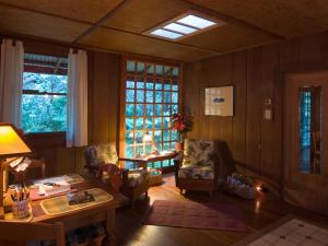 a living room with a table and chairs and windows at Crater Rim Cabin in Volcano