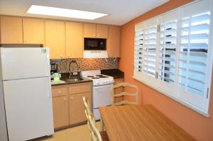 a kitchen with a white refrigerator and a table at Sun Viking Lodge - Daytona Beach in Daytona Beach