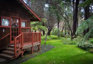 a wooden house with a porch and a yard at Crater Rim Cabin in Volcano