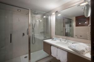 a bathroom with a shower and a sink and a tub at Due Lune Puntaldia Resort & Golf in San Teodoro