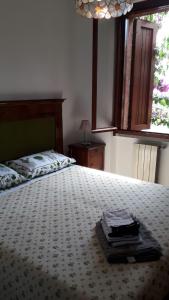 a bedroom with a bed with a book on it at Holiday House Camillina in Salò