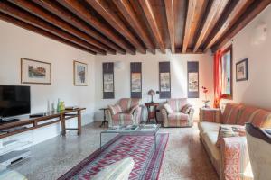 a living room with a couch and a tv at Ca' Coriandolo in Venice