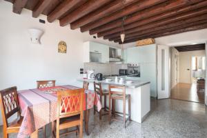 a kitchen and dining room with a table and chairs at Ca' Coriandolo in Venice