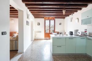 a kitchen with white cabinets and a wooden ceiling at Ca' Coriandolo in Venice