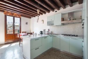 a kitchen with white cabinets and a large window at Ca' Coriandolo in Venice