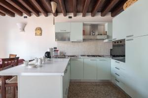 a white kitchen with white cabinets and appliances at Ca' Coriandolo in Venice