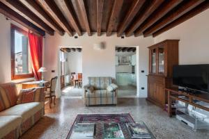 a living room with a couch and a tv at Ca' Coriandolo in Venice