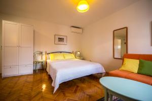una camera da letto con un letto e un divano di Studio apartment Lux a Rovigno (Rovinj) Altre 2 foto