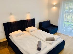 a bedroom with a large bed and a blue chair at Wojtecki Apartamenty in Pobierowo