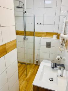 bagno con lavandino e doccia di Wojtecki Apartamenty a Pobierowo