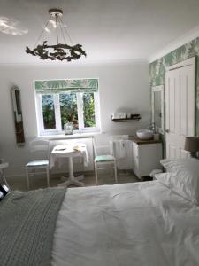 sypialnia z łóżkiem, stołem i oknem w obiekcie Darceys in the Yard w mieście Hornsea