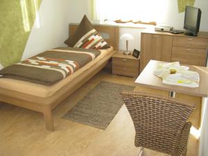 Schlafzimmer mit einem Bett und einem Schreibtisch mit einem TV in der Unterkunft Hefterwaldstüble in Schramberg