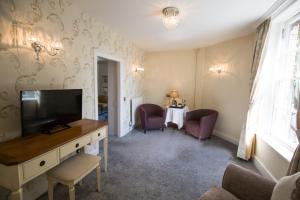a living room with a television and a table at Rossett Hall Hotel in Rossett