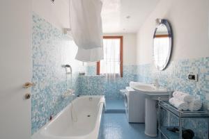 a blue and white bathroom with a tub and a sink at Ca' Coriandolo in Venice +37 photos