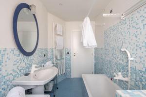a blue and white bathroom with a sink and a mirror at Ca' Coriandolo in Venice