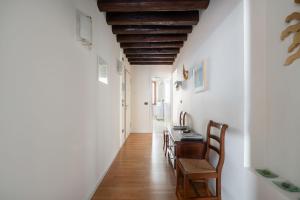 a hallway with white walls and a table and chairs at Ca' Coriandolo in Venice