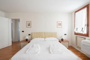a bedroom with a large white bed and a window at Ca' Coriandolo in Venice