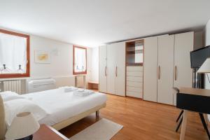 a white bedroom with a white bed and a television at Ca' Coriandolo in Venice