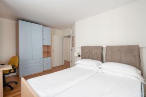 a bedroom with a large white bed and a desk at Ca' Coriandolo in Venice