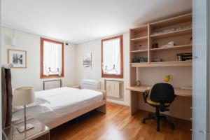 a bedroom with a bed and a desk and a chair at Ca' Coriandolo in Venice