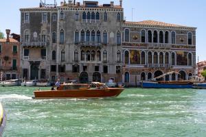 a boat in the water in front of a building at Ca' Coriandolo in Venice