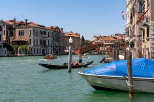 two boats are docked on a river in a city at Ca' Coriandolo in Venice