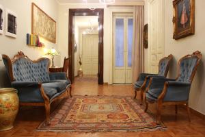 uma sala de estar com três cadeiras e um tapete em Umberto House Catania em Catânia