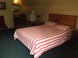 a red and white striped bed in a room at Big South Fork Trail Lodge in Stearns
