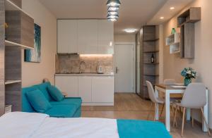 a bedroom with a blue couch and a table and a kitchen at SkyTop Studios in Gudauri