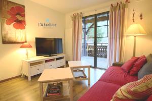 a living room with a couch and a flat screen tv at Le Petit Verger 104 in Saint-Lary-Soulan