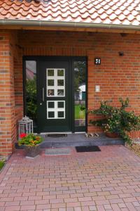 a green door on a brick house with flowers at Landhaus - Hof Pakirnis in Bleckede