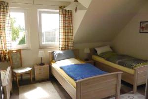 a small bedroom with two beds and a window at Landhaus - Hof Pakirnis in Bleckede