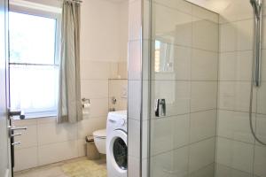 a bathroom with a washing machine in a shower at Landhaus - Hof Pakirnis in Bleckede