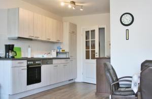 a kitchen with white cabinets and a clock on a wall at Landhaus - Hof Pakirnis in Bleckede +13 photos