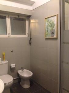 a bathroom with a white toilet and a sink at Palm Guesthouse B&B Rooms in Cascais