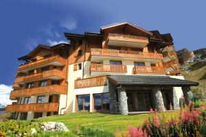 a large building with balconies on top of a hill at Lagrange Vacances L'Arollaie in Peisey-Nancroix