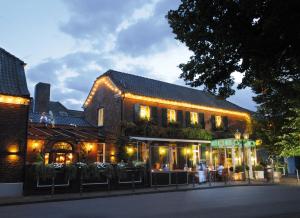 Ein Gebäude mit Leuten, die draußen sitzen. in der Unterkunft Wellings Romantik Hotel zur Linde in Moers